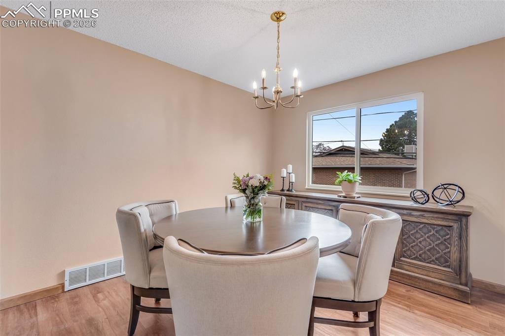 110 Monk Street Colorado Springs, CO 80911 - Photo 14 of 34 a dining room with furniture a chandelier and wooden floor