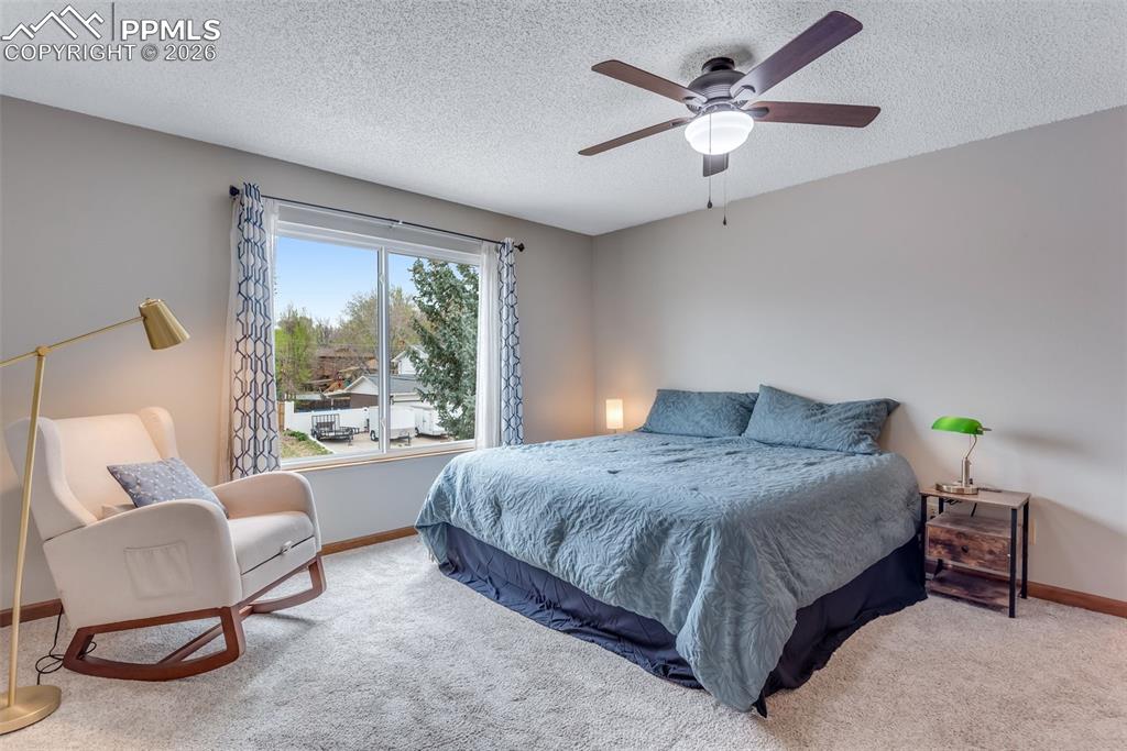 110 Monk Street Colorado Springs, CO 80911 - Photo 21 of 34 a spacious bedroom with a bed a couch and a chandelier