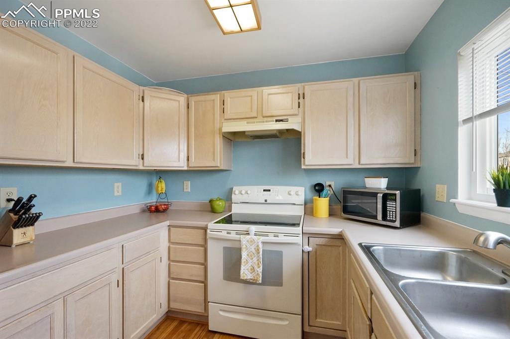 5805 Dutchess Drive Colorado Springs, CO 80923 - Photo 11 of 34 a kitchen with white cabinets and white appliances