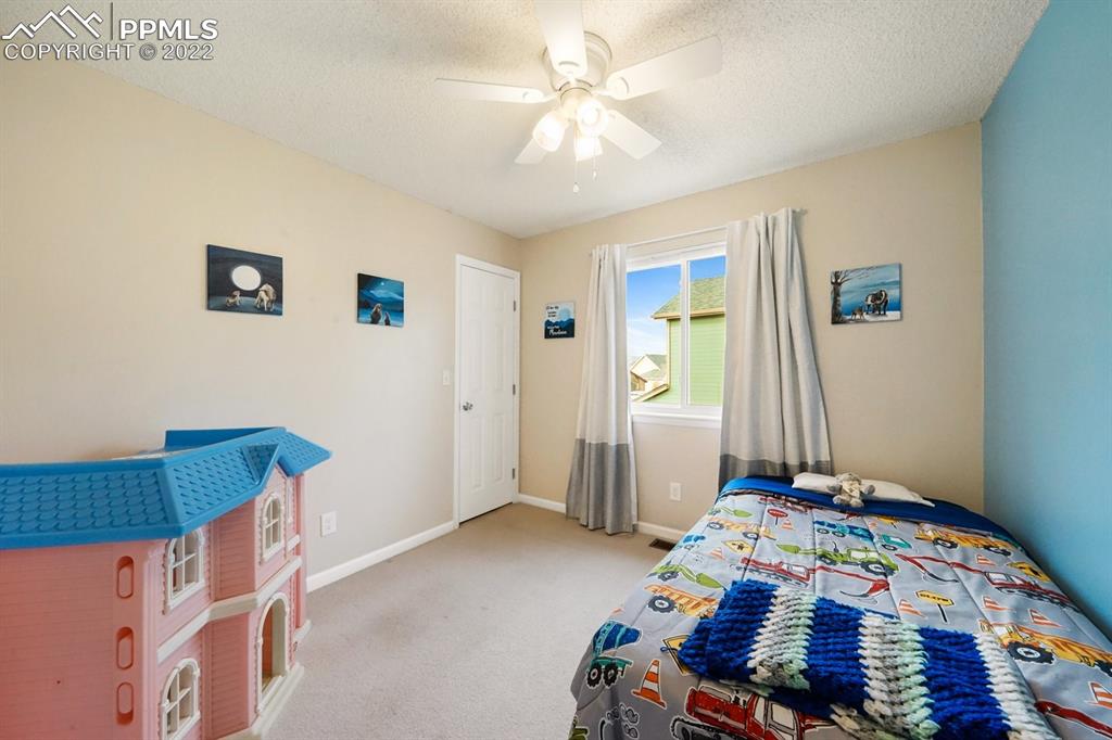 5805 Dutchess Drive Colorado Springs, CO 80923 - Photo 12 of 34 a bedroom with a bed and a chandelier