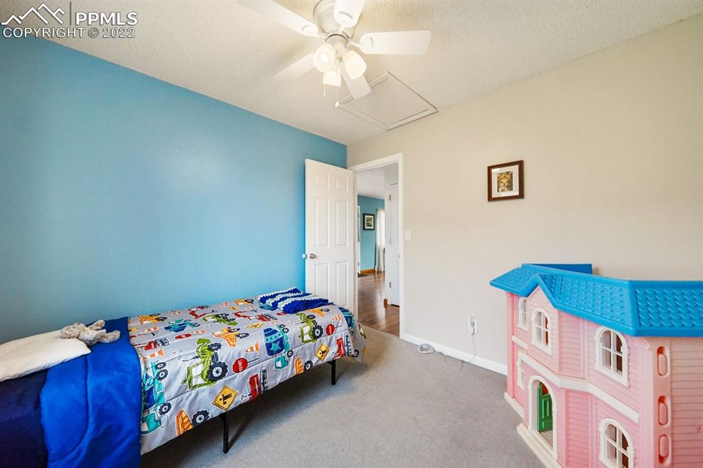 5805 Dutchess Drive Colorado Springs, CO 80923 - Photo 13 of 34 a bedroom with a bed and a dresser