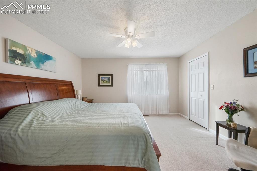 5805 Dutchess Drive Colorado Springs, CO 80923 - Photo 14 of 34 a bedroom with a bed and a chandelier
