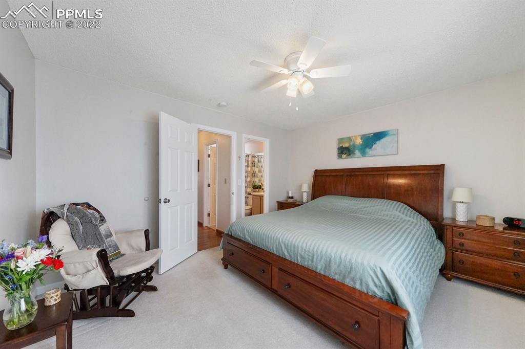 5805 Dutchess Drive Colorado Springs, CO 80923 - Photo 15 of 34 a bedroom with a bed and a chandelier