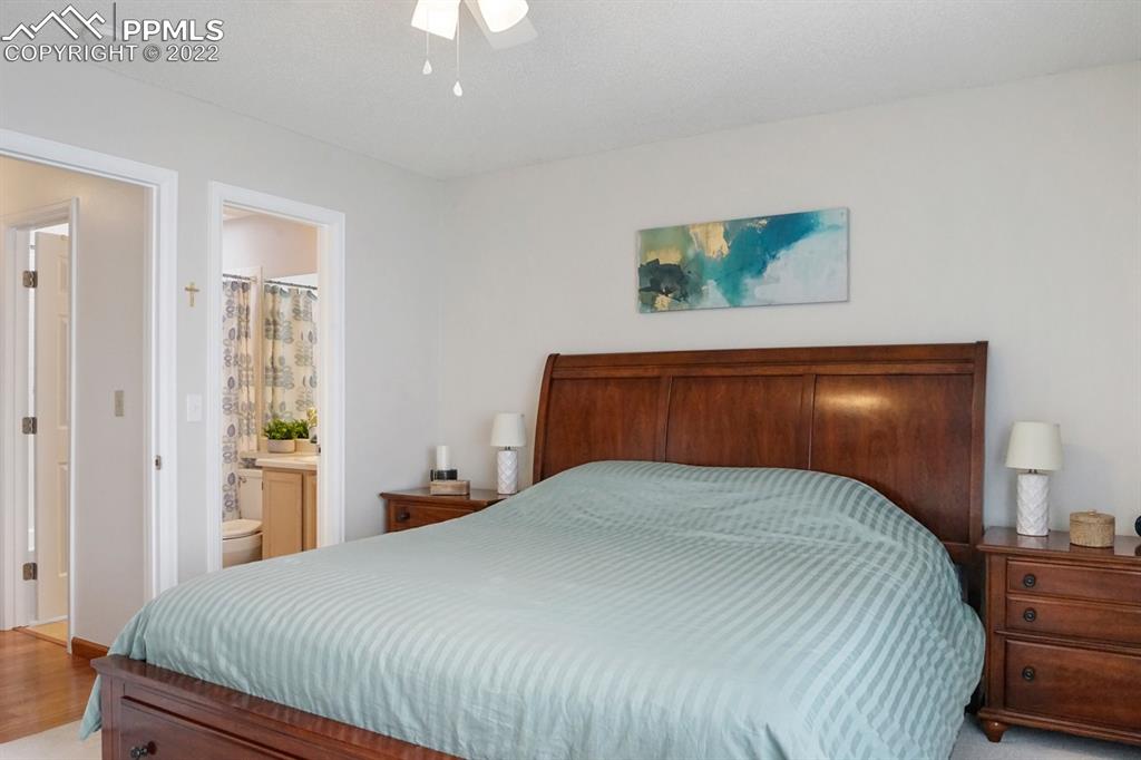 5805 Dutchess Drive Colorado Springs, CO 80923 - Photo 16 of 34 a bedroom with a bed and painting on the wall