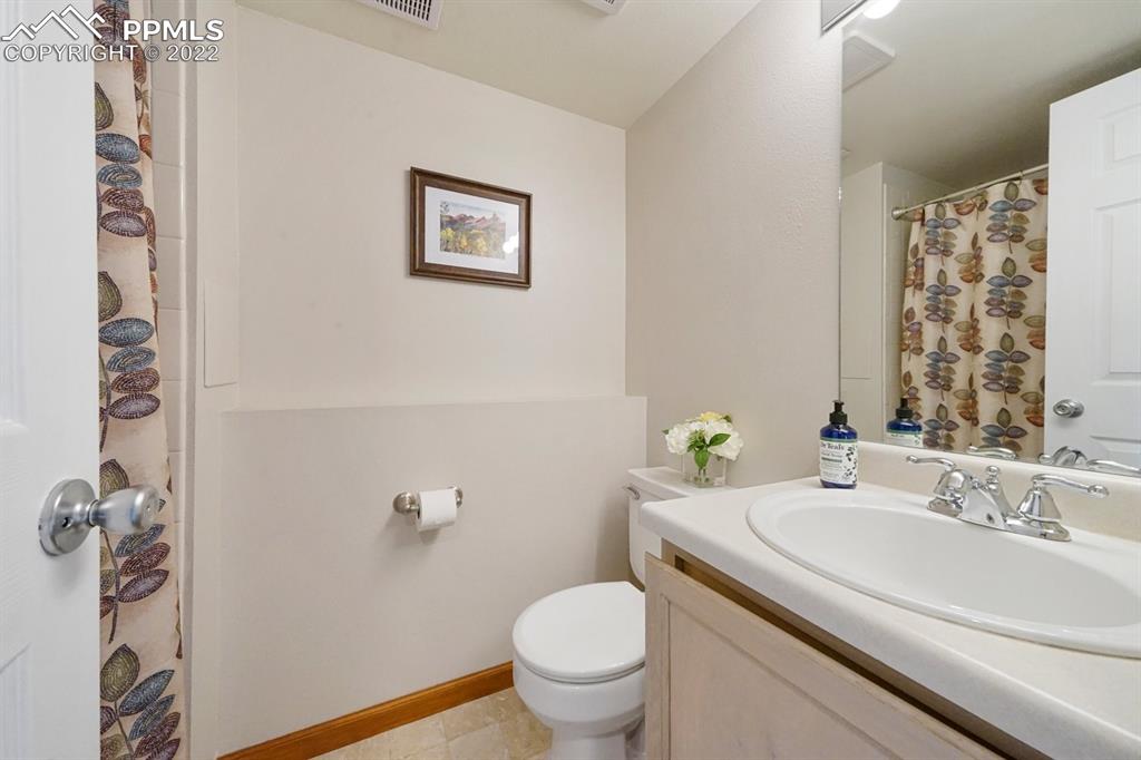 5805 Dutchess Drive Colorado Springs, CO 80923 - Photo 21 of 34 a bathroom with a sink a toilet and a mirror