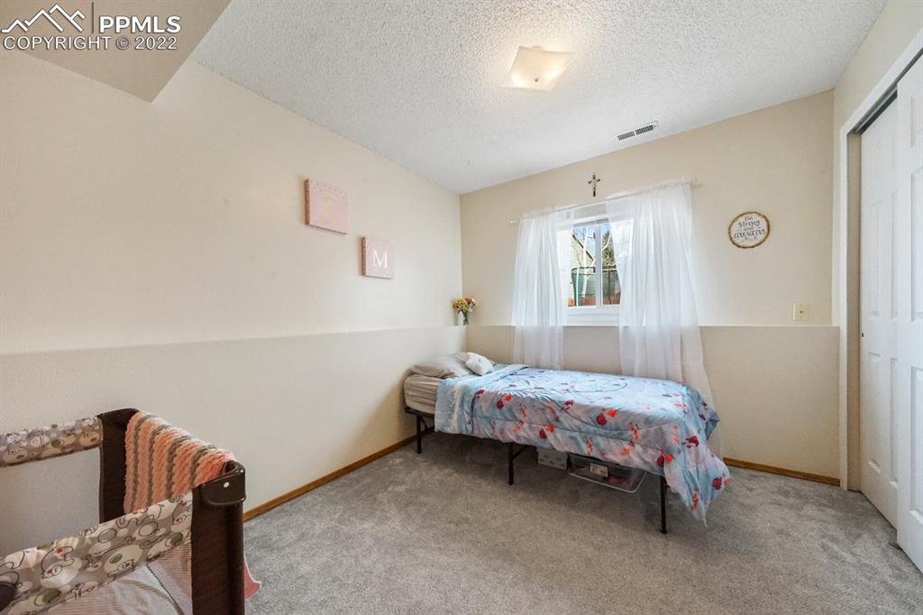 5805 Dutchess Drive Colorado Springs, CO 80923 - Photo 23 of 34 a bedroom with a bed and a window
