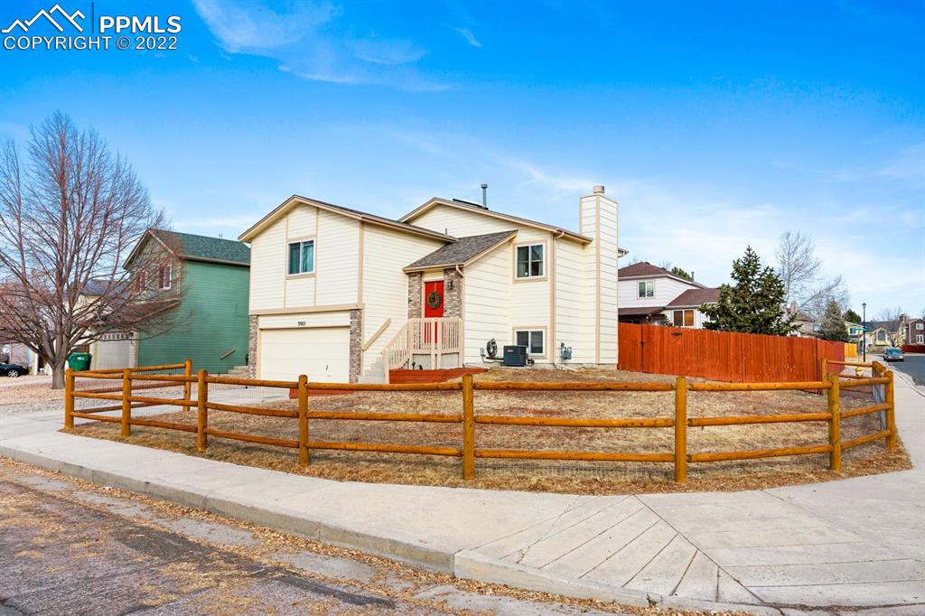 5805 Dutchess Drive Colorado Springs, CO 80923 - Photo 31 of 34 a view of a house with a small yard and potted plants