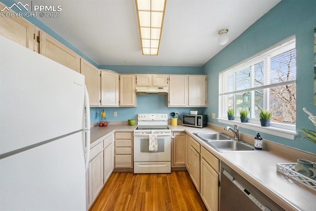 5805 Dutchess Drive Colorado Springs, CO 80923 - Photo 9 of 34 a kitchen with a sink a window a counter top space stainless steel appliances and cabinets
