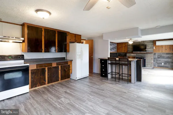 a kitchen with stainless steel appliances granite countertop a refrigerator a stove and a wooden floors