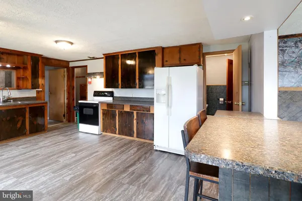 a kitchen with a table chairs refrigerator and a microwave