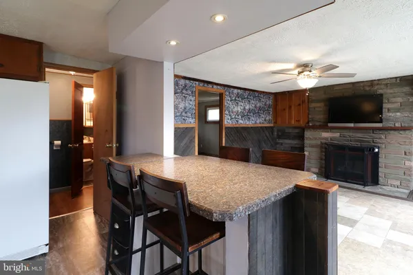 a kitchen with stainless steel appliances kitchen island granite countertop a refrigerator a stove a microwave oven a dining table and chairs with wooden floor