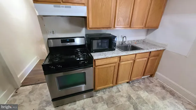 a kitchen with wooden cabinets and a stove top oven