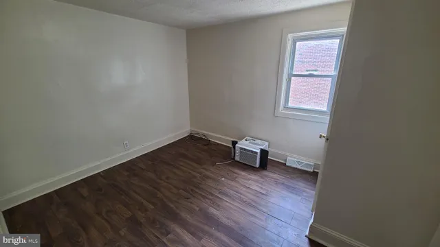 a view of a room with wooden floor and a window