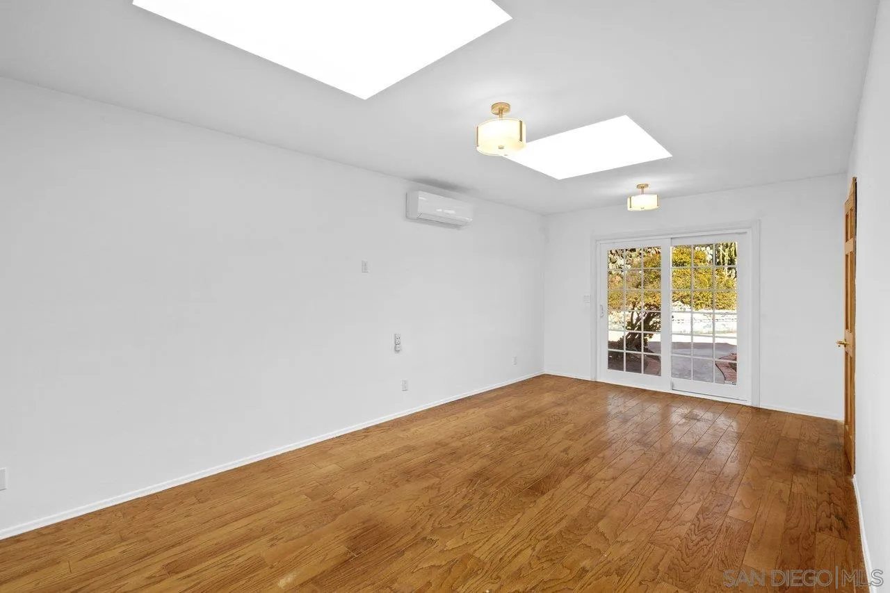 2169 Rockhoff Road Escondido, CA 92026 - Photo 16 of 22 an empty room with wooden floor and windows