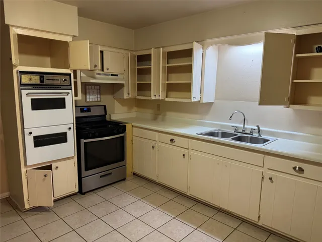 a kitchen with stainless steel appliances a stove sink and microwave