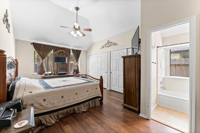 a bedroom with bed mirror and window