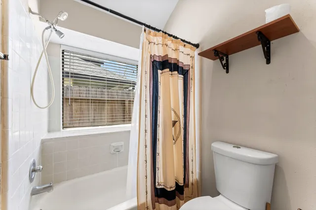 a bathroom with a toilet and a shower