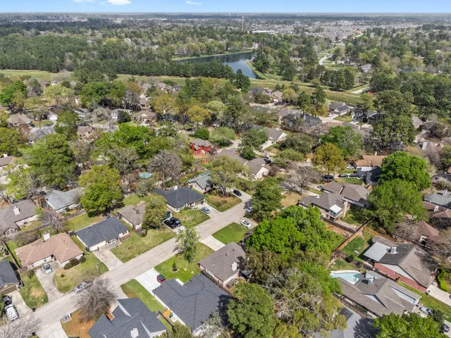 an aerial view of residential houses with outdoor space and trees