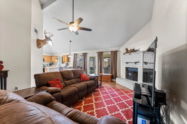 a living room with furniture a fireplace and a chandelier