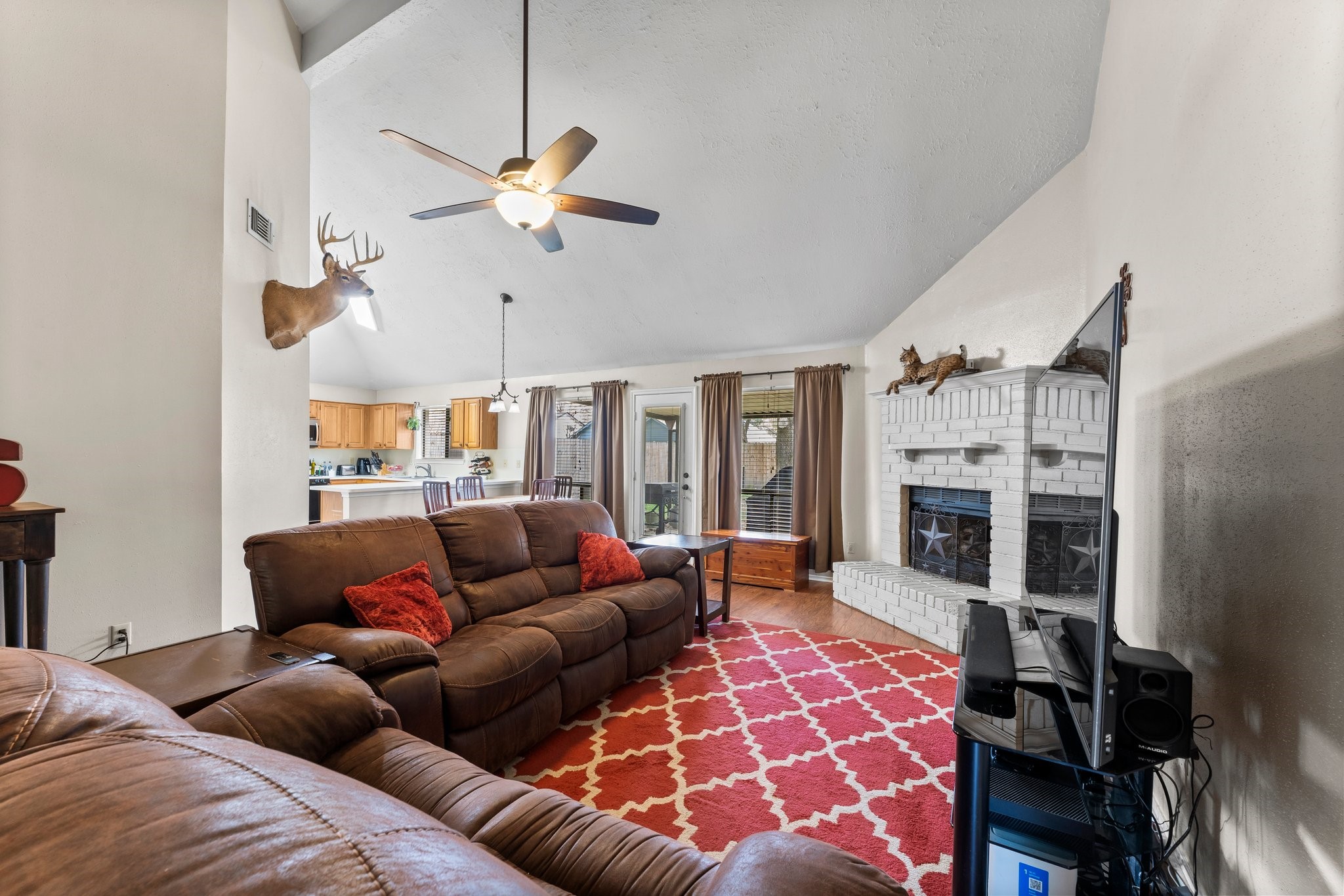 2110 Creston Drive Spring, TX 77386 - Photo 10 of 50 a living room with furniture a fireplace and a chandelier