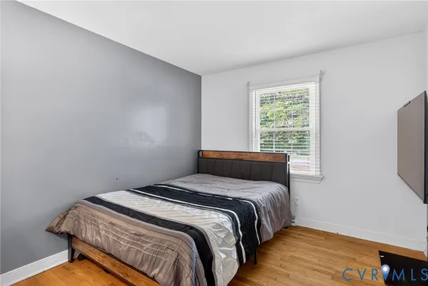 a bedroom with a bed and a flat tv screen on a dresser