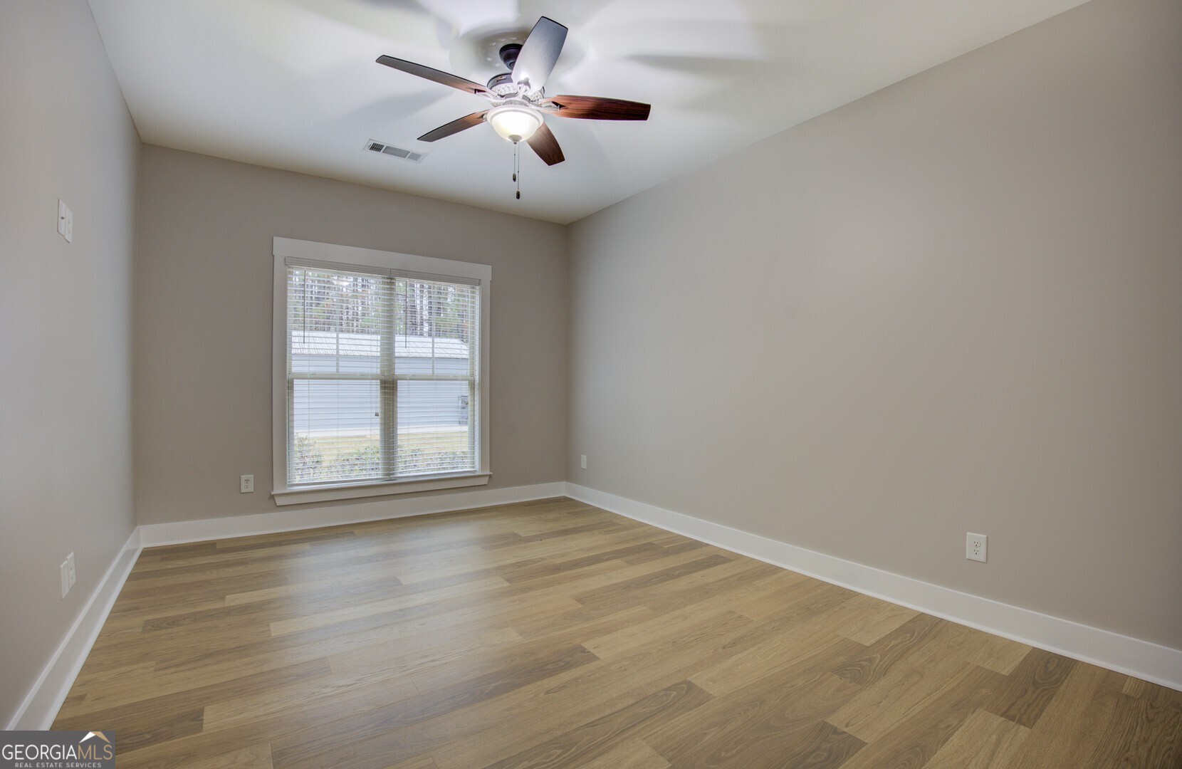 284 Sowell Road McDonough, GA 30252 - Photo 35 of 48 an empty room with wooden floor ceiling fan and windows