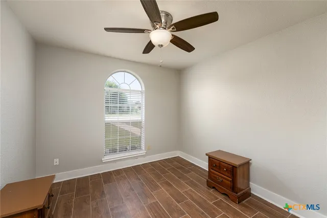 a view of room with a ceiling fan and a window