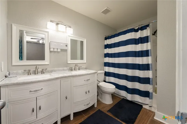 a spacious bathroom with a double vanity sink and a mirror