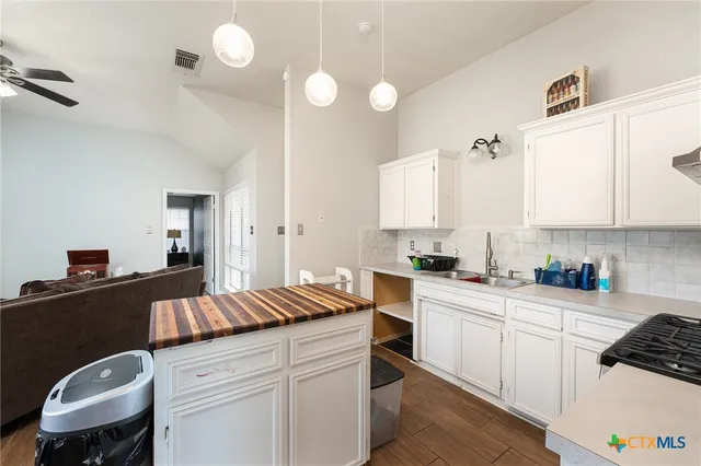 a kitchen with a sink cabinets and wooden floor