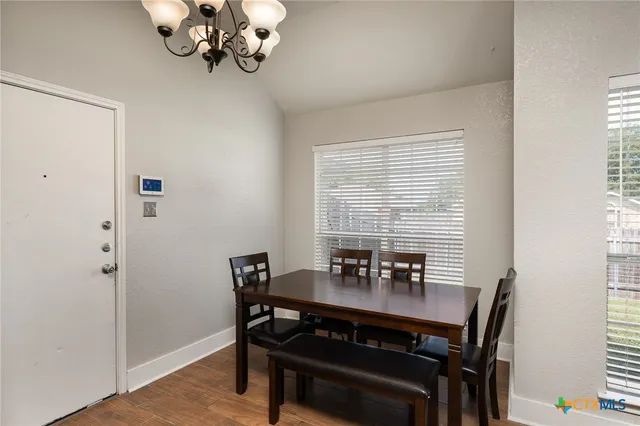 a view of a dining room with a table and chairs