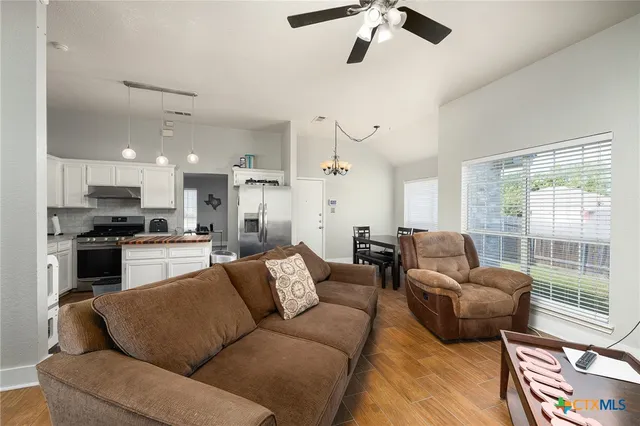 a living room with furniture kitchen and a large window