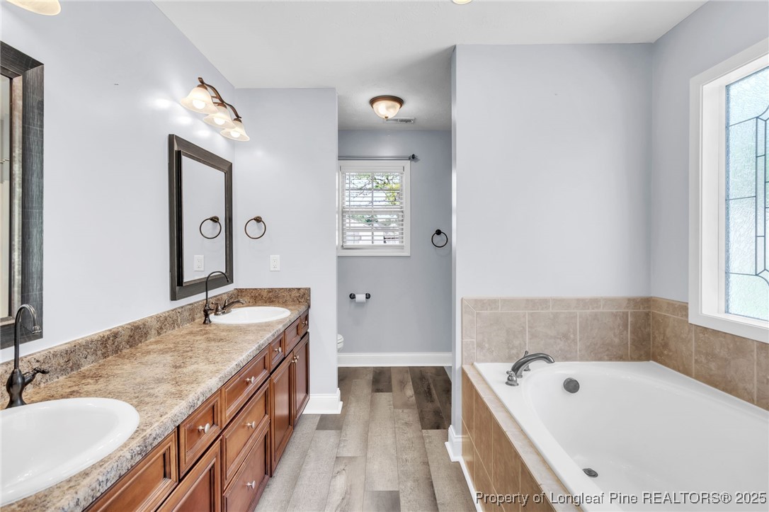 510 Hammond Farms Road Hope Mills, NC 28348 - Photo 18 of 49 a bathroom with a granite countertop tub sink and mirror