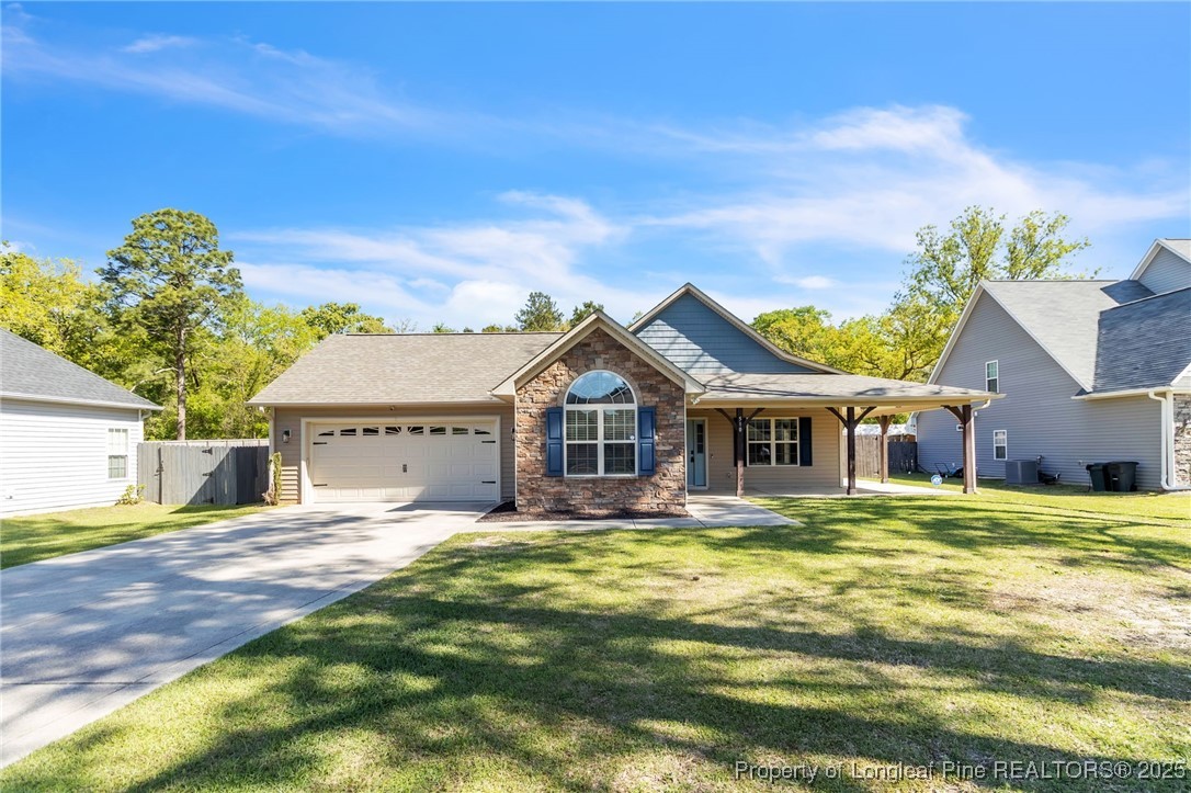 510 Hammond Farms Road Hope Mills, NC 28348 - Photo 2 of 49 a front view of a house with a garden and trees