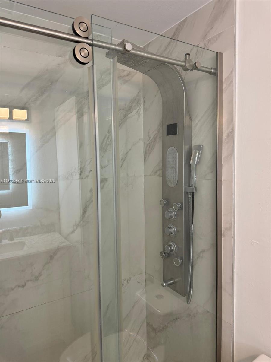 18101 Northwest 68th Avenue, Unit D207 Hialeah, FL 33015 - Photo 16 of 18 a bathroom with a glass door shower