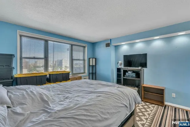 a bedroom with a bed and a flat screen tv