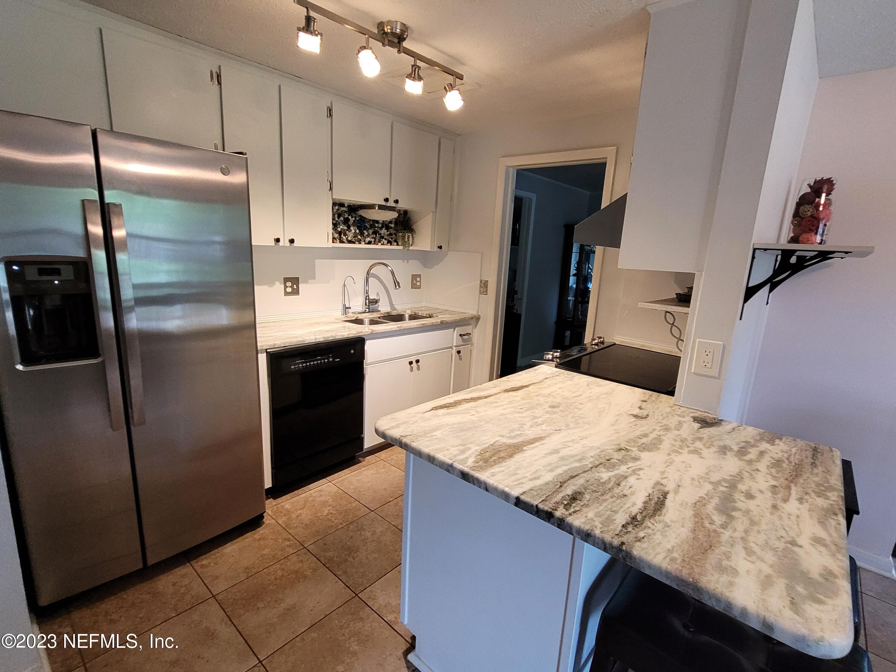 1050 Perkins Place Jacksonville, FL 32221 - Photo 4 of 18 a kitchen with kitchen island sink refrigerator and cabinets