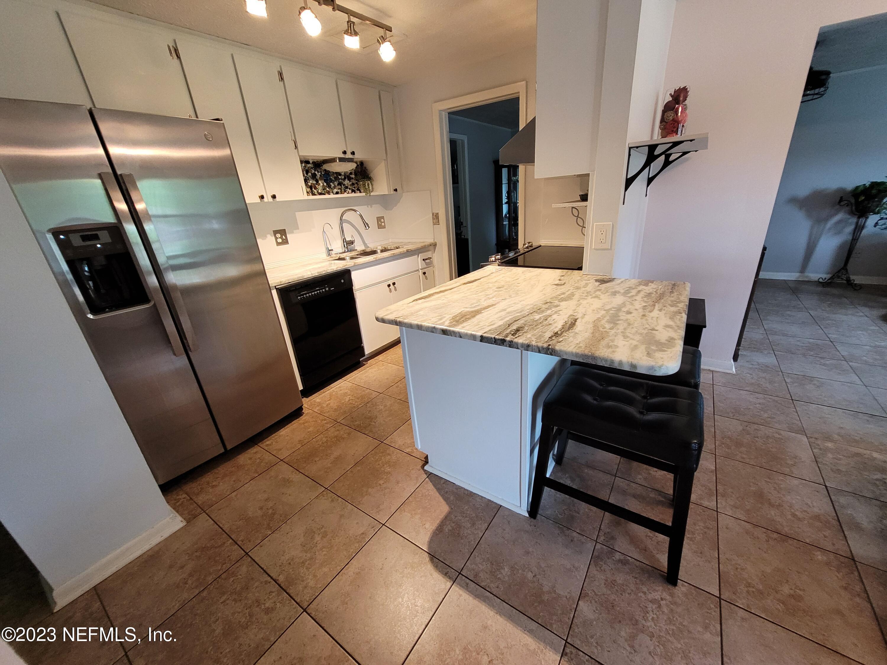 1050 Perkins Place Jacksonville, FL 32221 - Photo 6 of 18 a kitchen with kitchen island a counter top space appliances and a counter top space