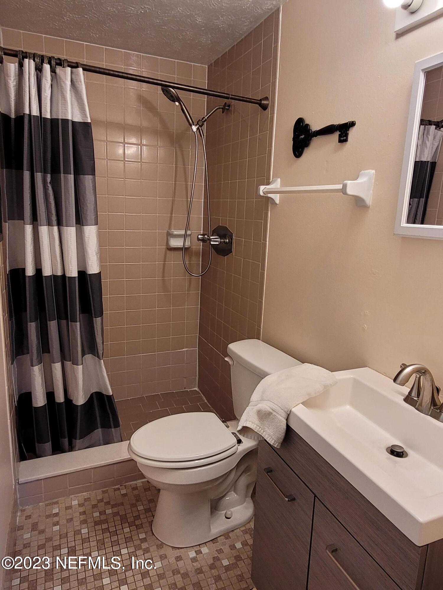 1050 Perkins Place Jacksonville, FL 32221 - Photo 8 of 18 a bathroom with a sink a toilet a shower and a mirror