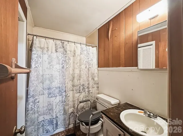 a bathroom with a granite countertop toilet and a sink