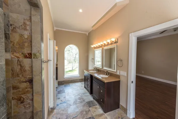a spacious bathroom with a granite countertop sink a mirror and shower