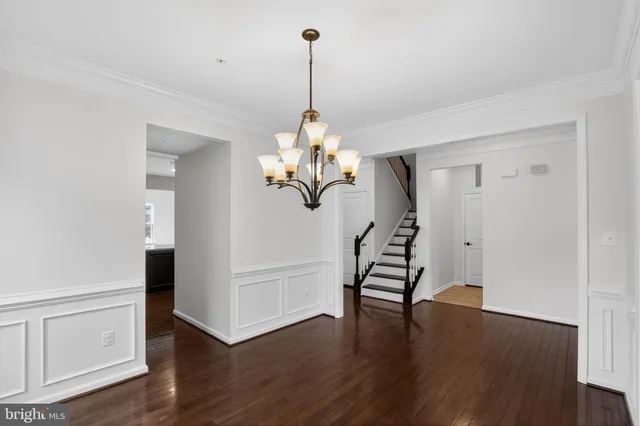 a dining room with wooden floor a chandelier a glass door and windows