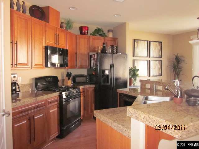 10759 Misty Meadows Drive Reno, NV 89521 - Photo 5 of 11 a kitchen with stainless steel appliances granite countertop a refrigerator a stove a sink a microwave and island