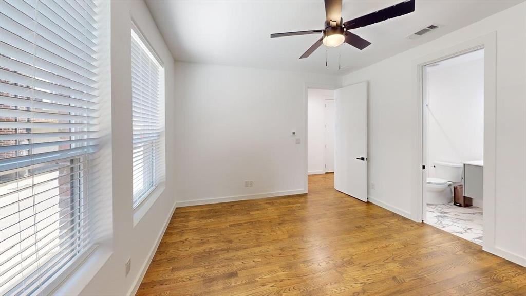 1552 Cosette Drive Dallas, TX 75215 - Photo 11 of 23 Unfurnished bedroom featuring light wood-style flooring, a ceiling fan, and connected bathroom