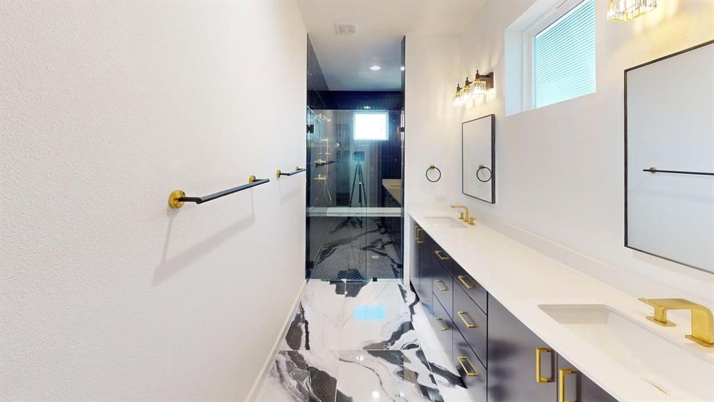 1552 Cosette Drive Dallas, TX 75215 - Photo 16 of 23 Full bath with double vanity, a shower stall, and light marble finish flooring