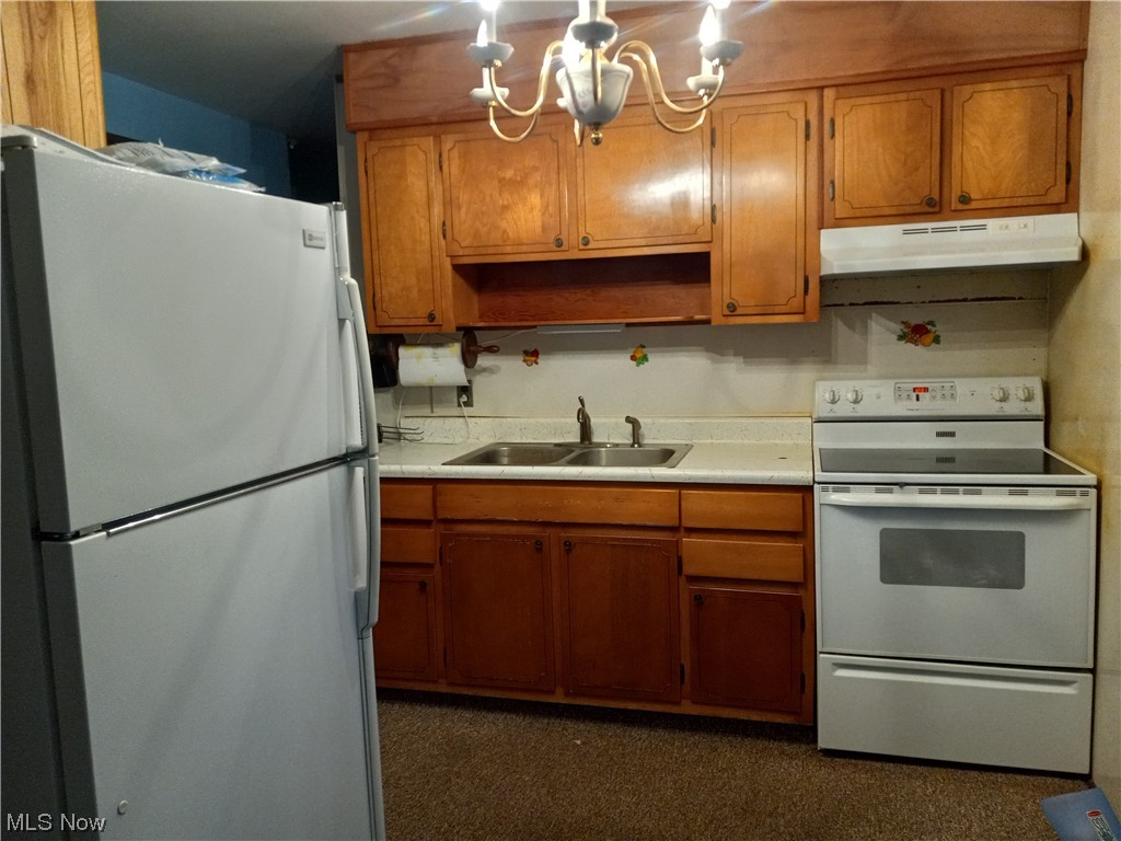 71695 Old Twenty One Road Kimbolton, OH 43749 - Photo 3 of 19 Kitchen with white appliances, a chandelier, sink, and dark carpet