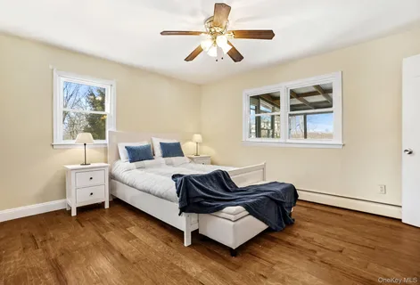 a spacious bedroom with a bed and wooden floor