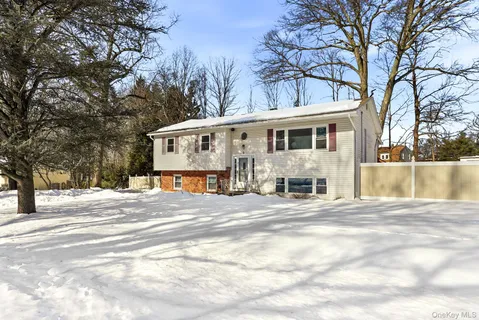 a view of a white house with a large tree