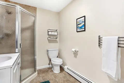 a bathroom with a granite countertop toilet and a shower