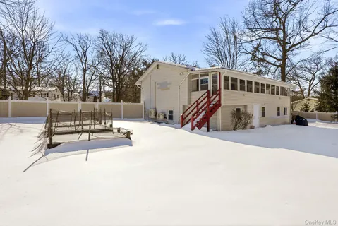 a view of a white house with a large tree