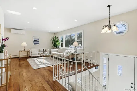 a view of a dining room and livingroom with furniture wooden floor a chandelier